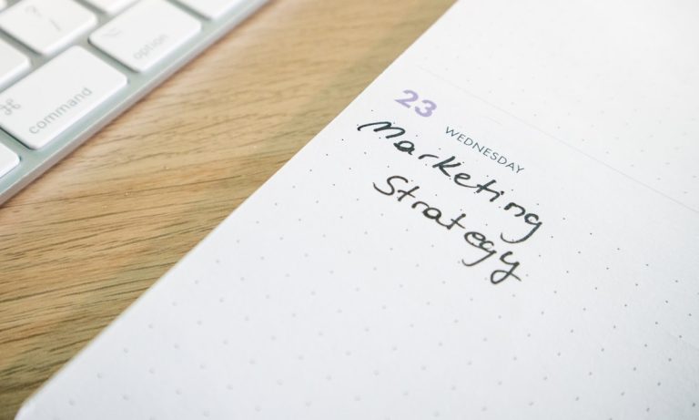 A notepad with the words marketing strategy written on it