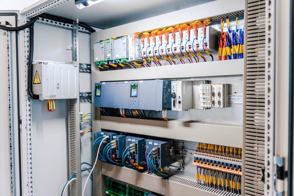 Open industrial electrical control panel with wires and modules.