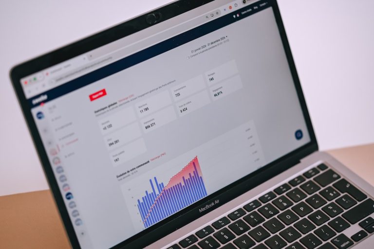 A laptop screen displays data analytics, charts, and statistics