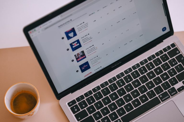 Laptop with content on screen and a cup of coffee